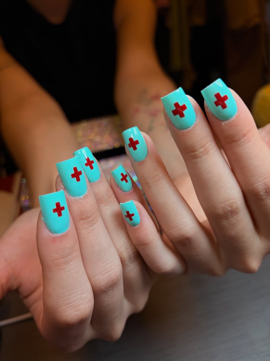 Vierkante turquoise nagels met rode kruisjes