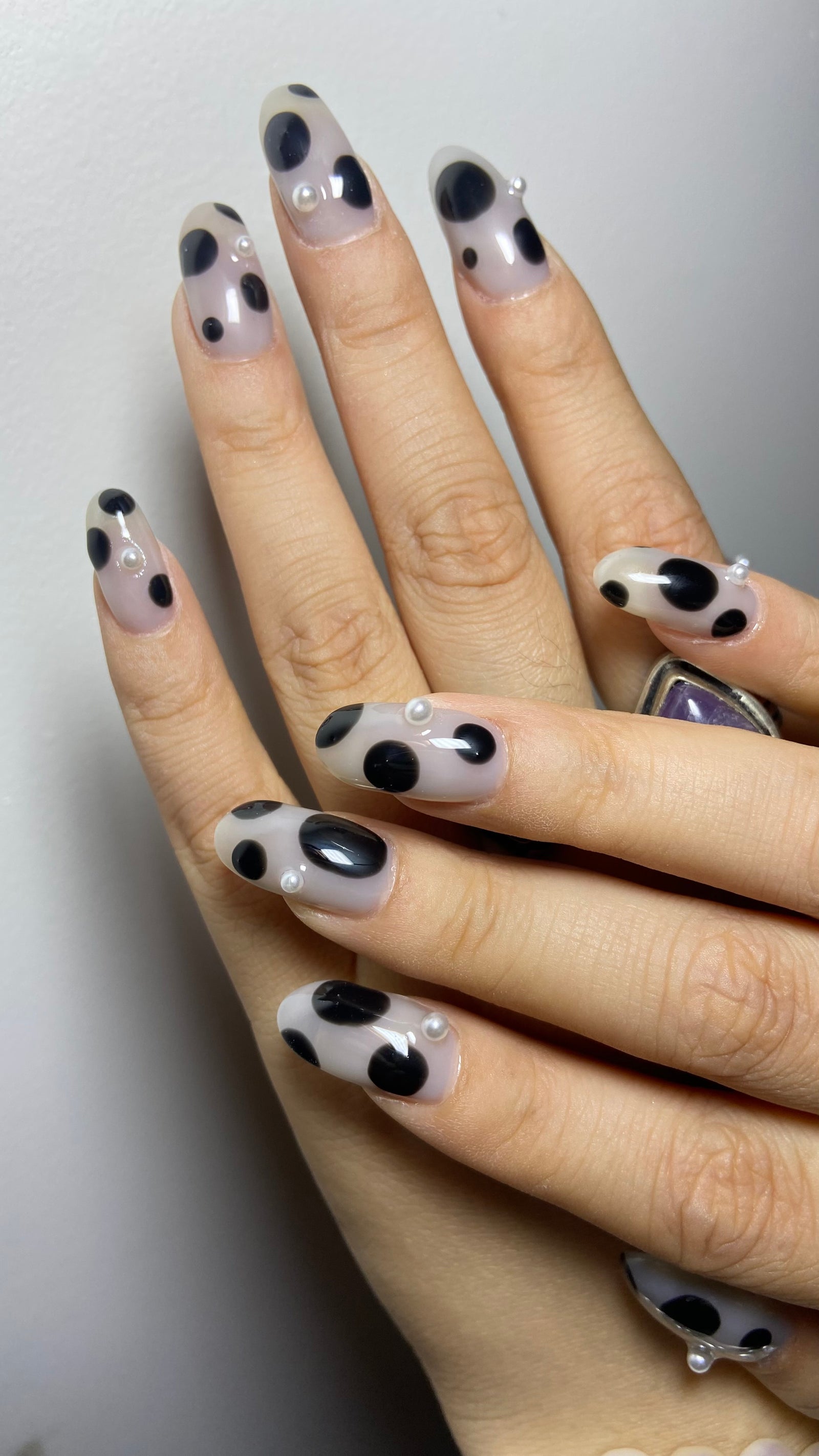 Lange amandelnagels met een zwart-wit koeienprint