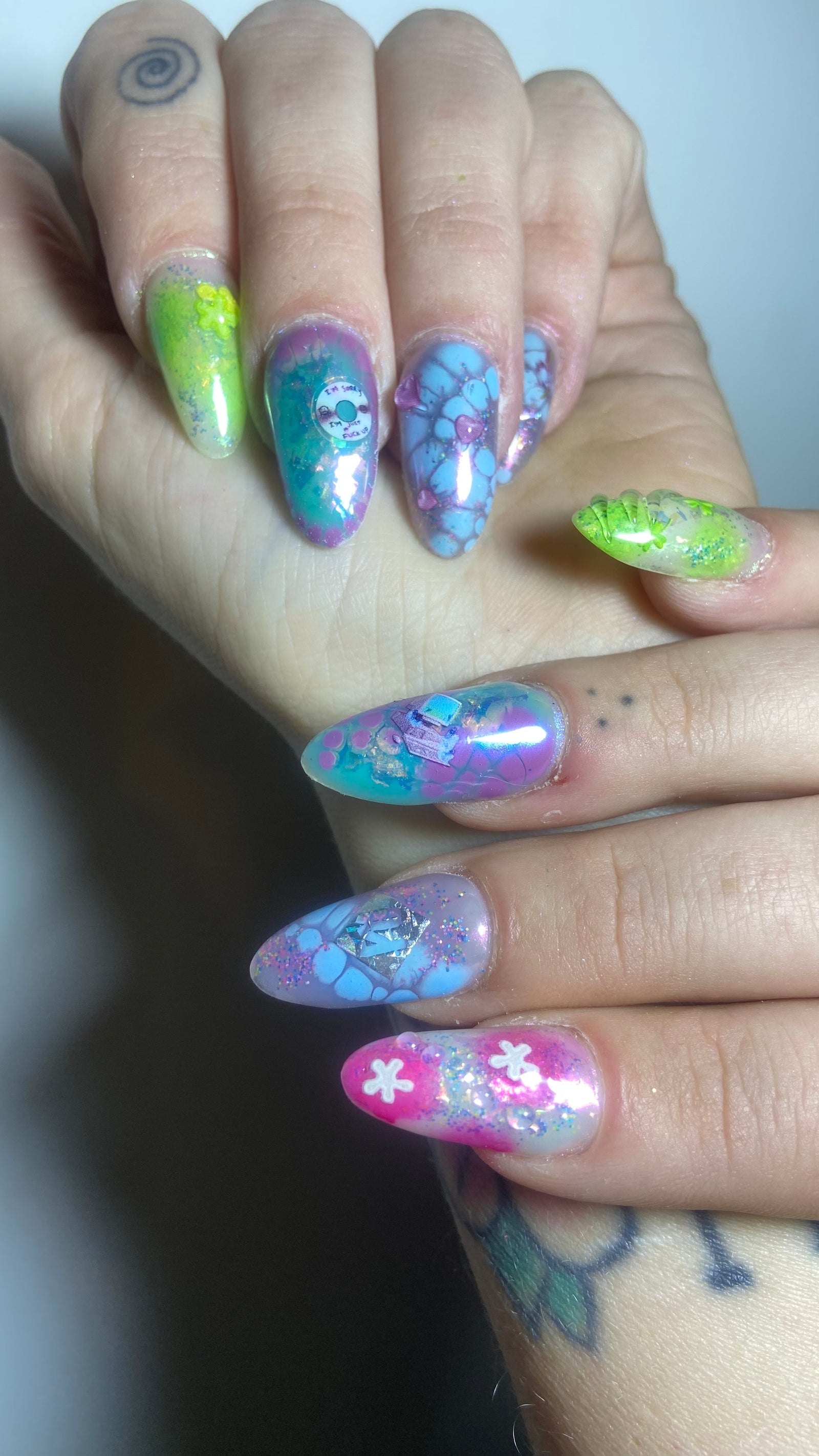 Doorschijnende lange amandelnagels met groene en blauwe bloemen